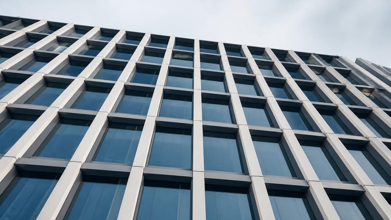 A repeating structural facade grid seen from below
