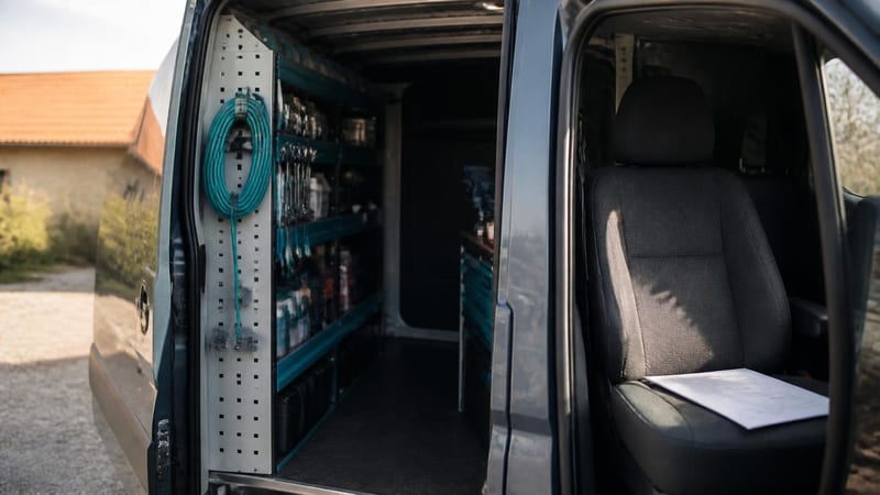 An open van side door with tools racked neatly inside