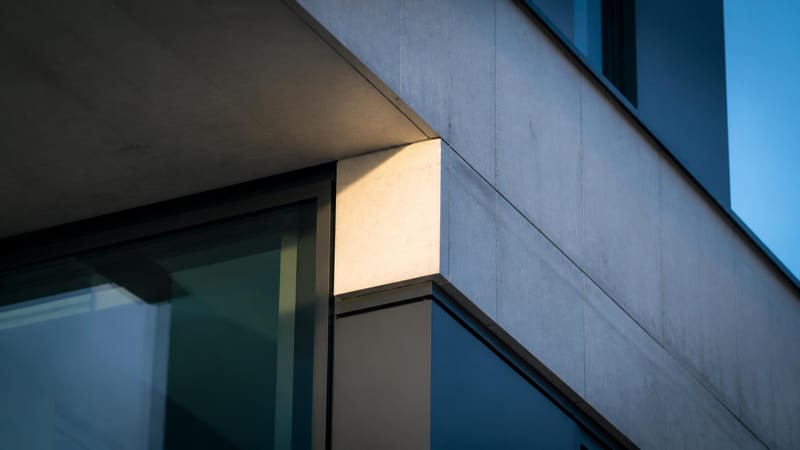A concrete and glass structural junction in hard directional light